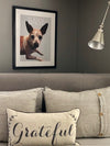 Pop art of dog in a black frame displayed in a nice bedroom