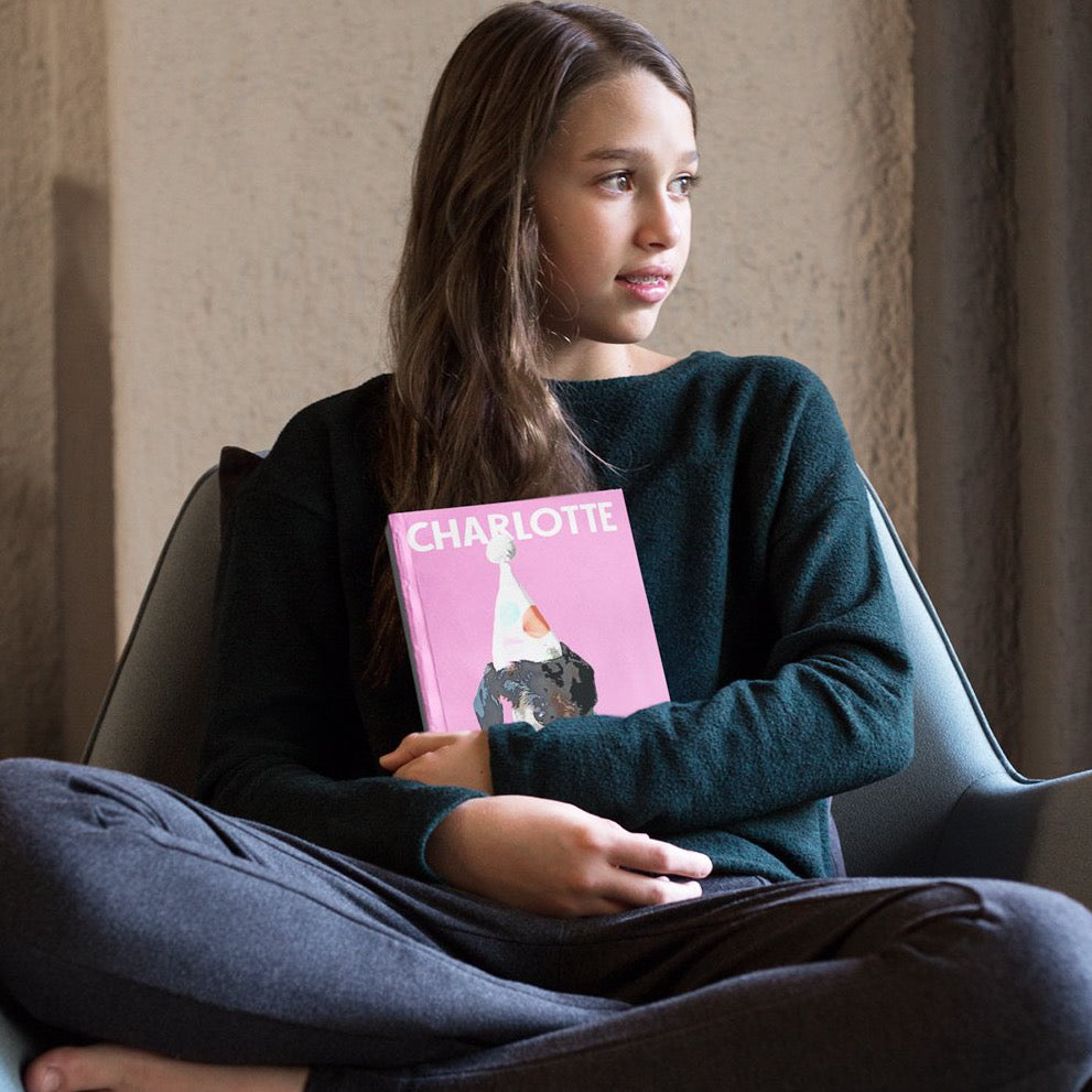 Young lady holding her Pink Poster custom bullet journal with a pop art of her dachshund dog on it